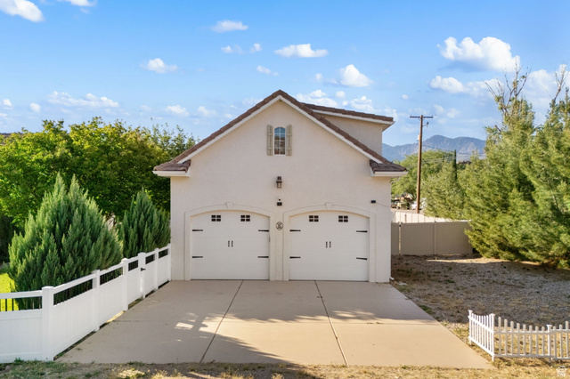 20 Valley Road Leeds, UT 84746 - Photo 53 of 57 Detached two-car garage with arched doors, sconce lighting, and an upper-level window