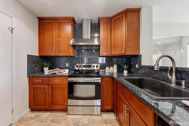 a kitchen with stainless steel appliances granite countertop a sink stove and cabinets