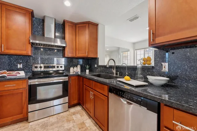 a kitchen with stainless steel appliances granite countertop a sink stove and cabinets