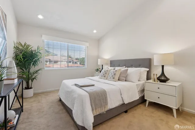 a bedroom with a bed and a potted plant
