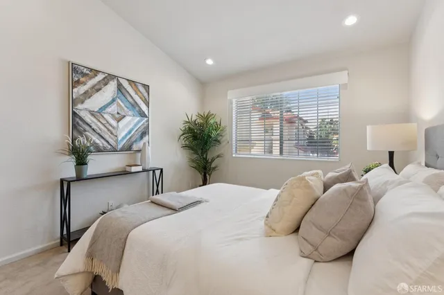 a bedroom with a bed and a painting on the wall