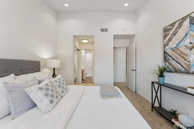 a spacious bedroom with a bed and a lamp