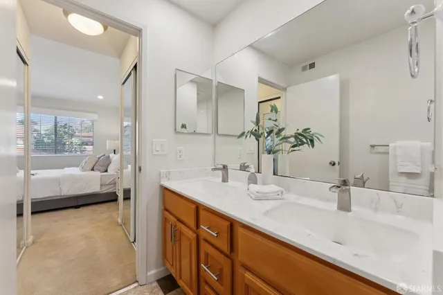 a en suite bathroom with a double vanity sink and a large mirror