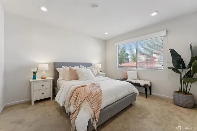 a bedroom with a bed and a potted plant