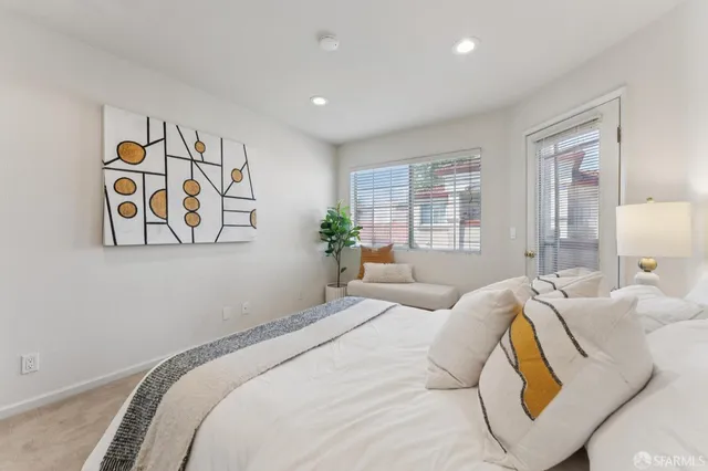 a bedroom with a large bed and a painting on the wall