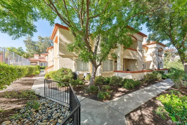 a front view of a building with streets and trees