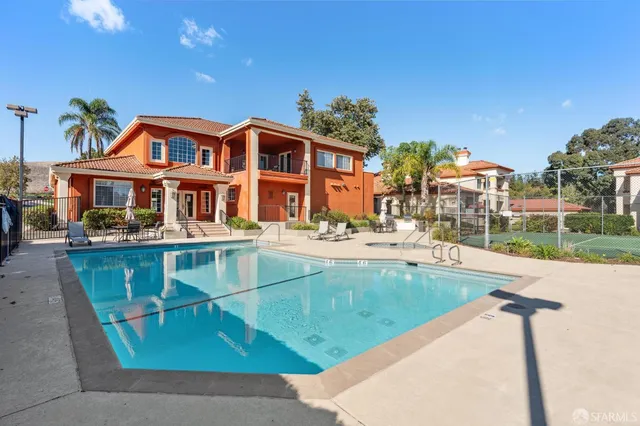 a view of a swimming pool with lawn chairs