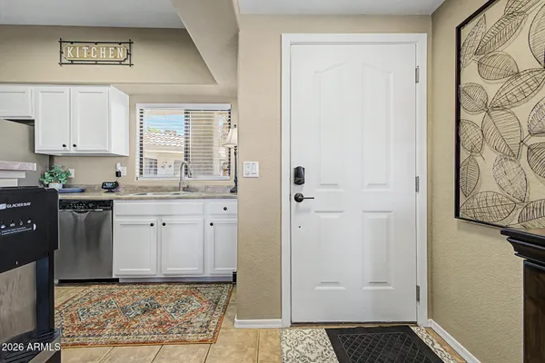 a kitchen with white cabinets and sink