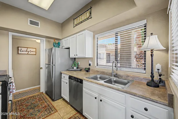 a kitchen with stainless steel appliances granite countertop a sink cabinets and a refrigerator
