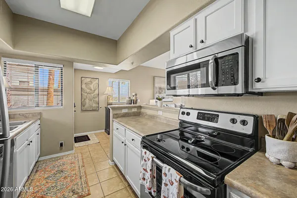 a kitchen with a stove a sink and wooden cabinets