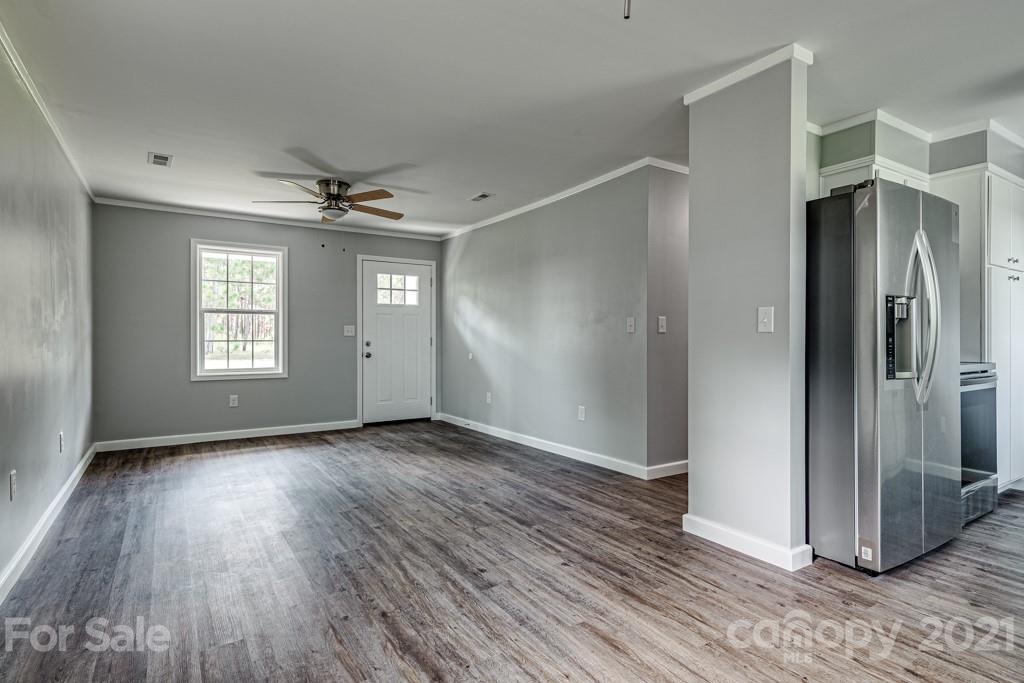1322 Miller-Flat Road, Unit 1 Jefferson, SC 29718 - Photo 21 of 32 an empty room with wooden floor a ceiling fan and windows
