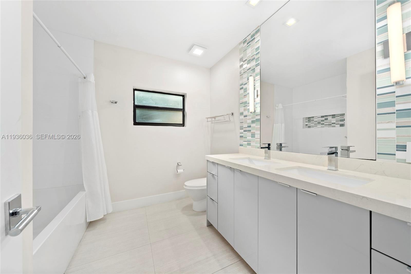 3141 North Bay Road Miami Beach, FL 33140 - Photo 30 of 50 a bathroom with a double vanity sink mirror and toilet