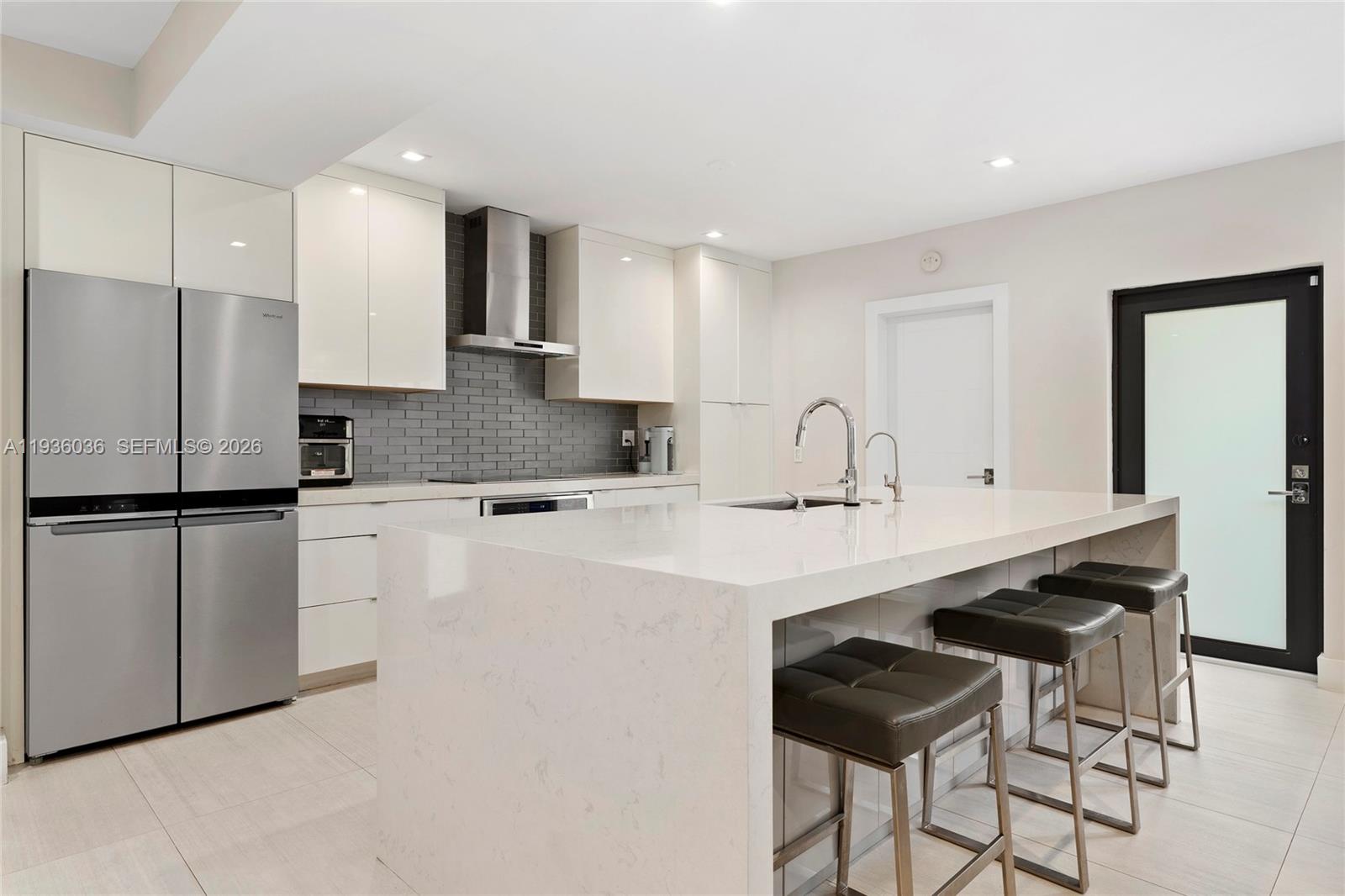 3141 North Bay Road Miami Beach, FL 33140 - Photo 9 of 50 a kitchen with stainless steel appliances a sink and a refrigerator