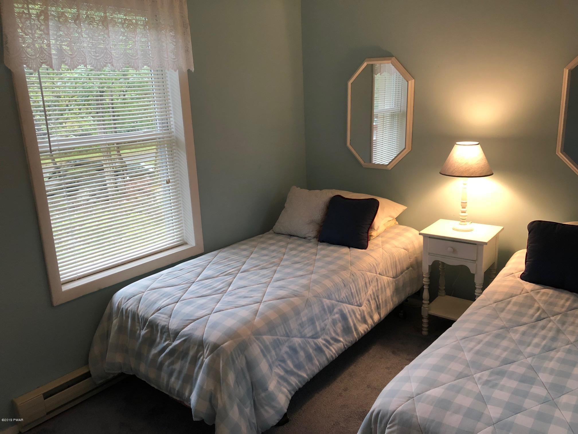 176 Heather Hill Road Dingmans Ferry, PA 18328 - Photo 15 of 32 a bedroom with bed and a window