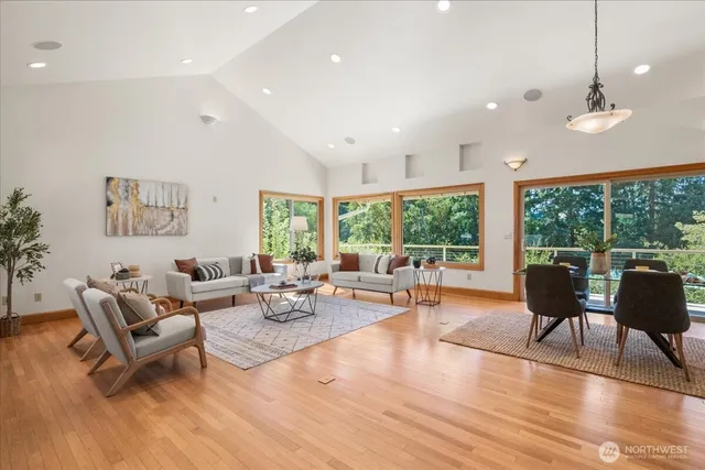 a view of a kitchen with kitchen island a large window cabinets a sink and stainless steel appliances