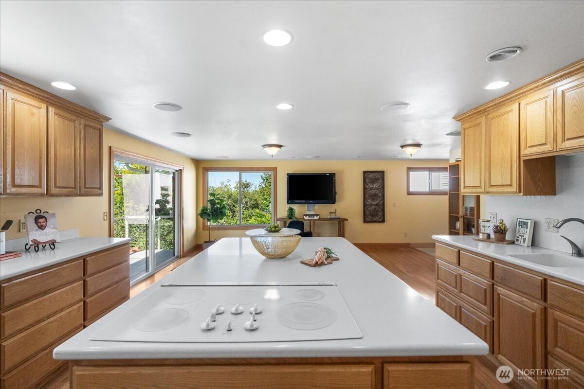 8707 45th Street West Tacoma, WA 98466 - Photo 13 of 39 a view of a kitchen with kitchen island a large window cabinets a sink and stainless steel appliances