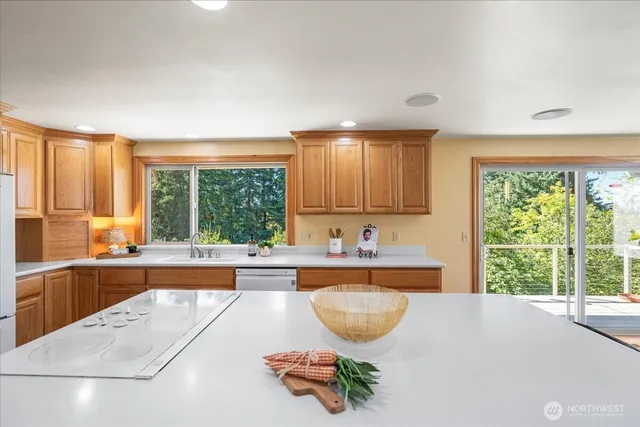 a large white kitchen with wooden floor and a refrigerator