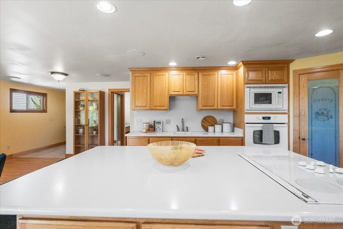 8707 45th Street West Tacoma, WA 98466 - Photo 15 of 39 a large white kitchen with wooden floor and a refrigerator