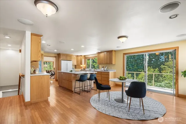 a kitchen with a dining table chairs and view of living room