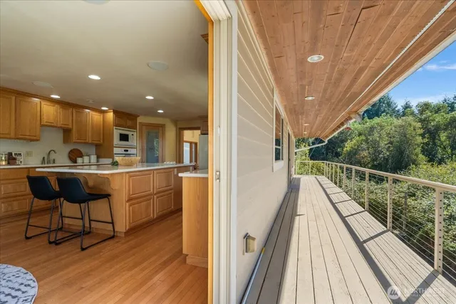 a balcony with chairs and wooden floor
