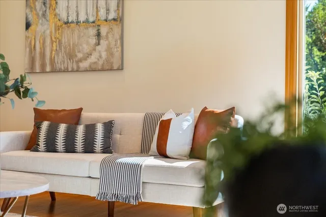 a living room with furniture a flat screen tv and large window
