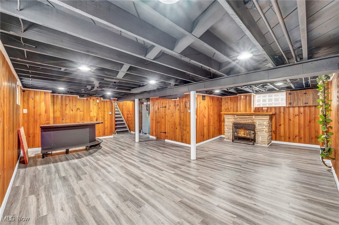 3577 Warren Road Cleveland, OH 44111 - Photo 13 of 17 Finished below grade area featuring wood walls, a fireplace, wood finished floors, baseboards, and stairway