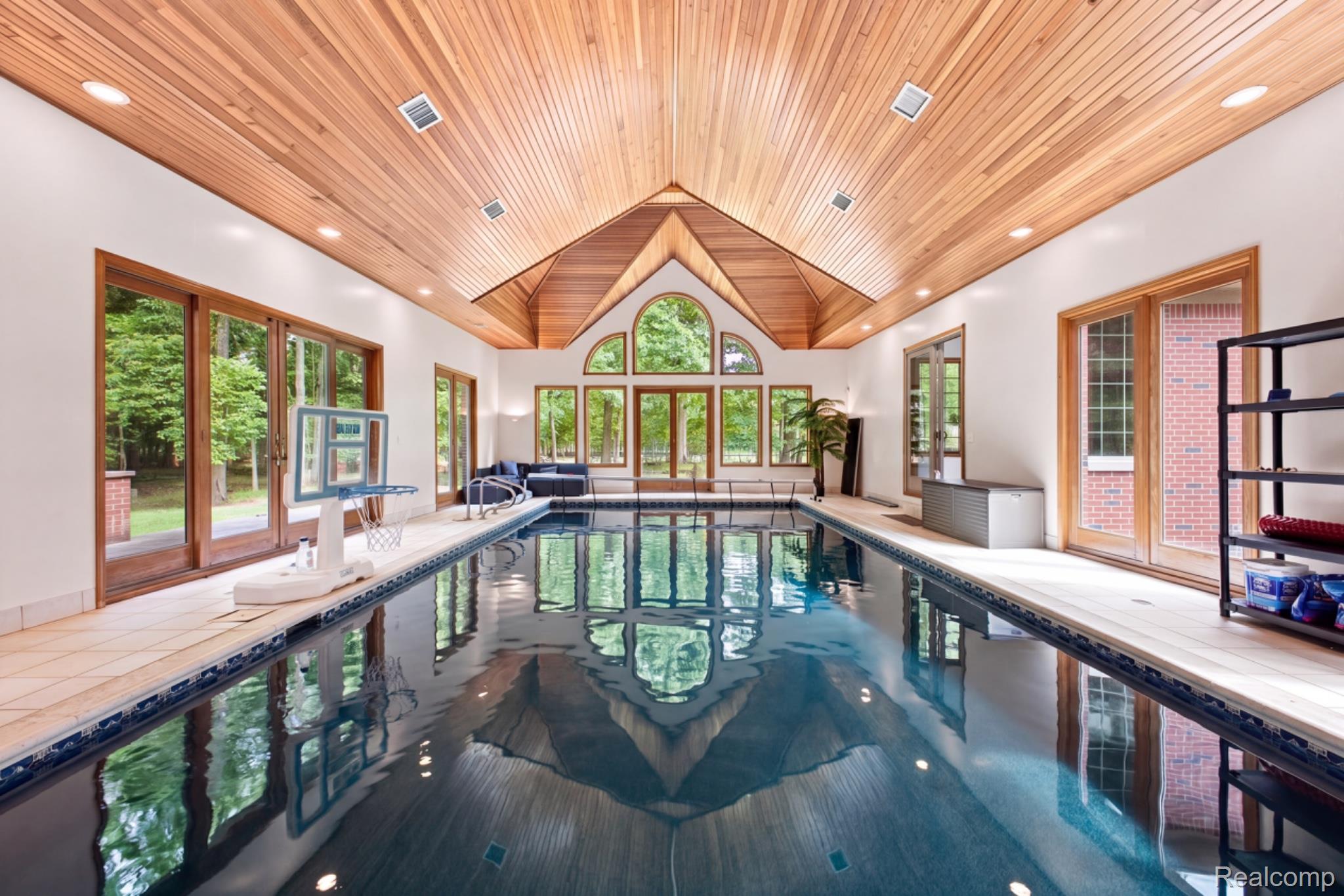 8610 Ferry Road Grosse Ile, MI 48138 - Photo 38 of 55 Indoor swimming pool with a wood-paneled vaulted ceiling, arched windows, and multiple sets of glass French doors