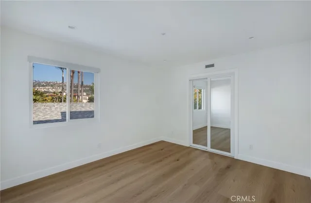 a view of a big room with wooden floor and windows