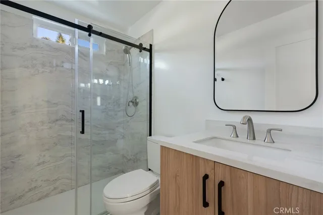 a bathroom with a granite countertop sink toilet and shower