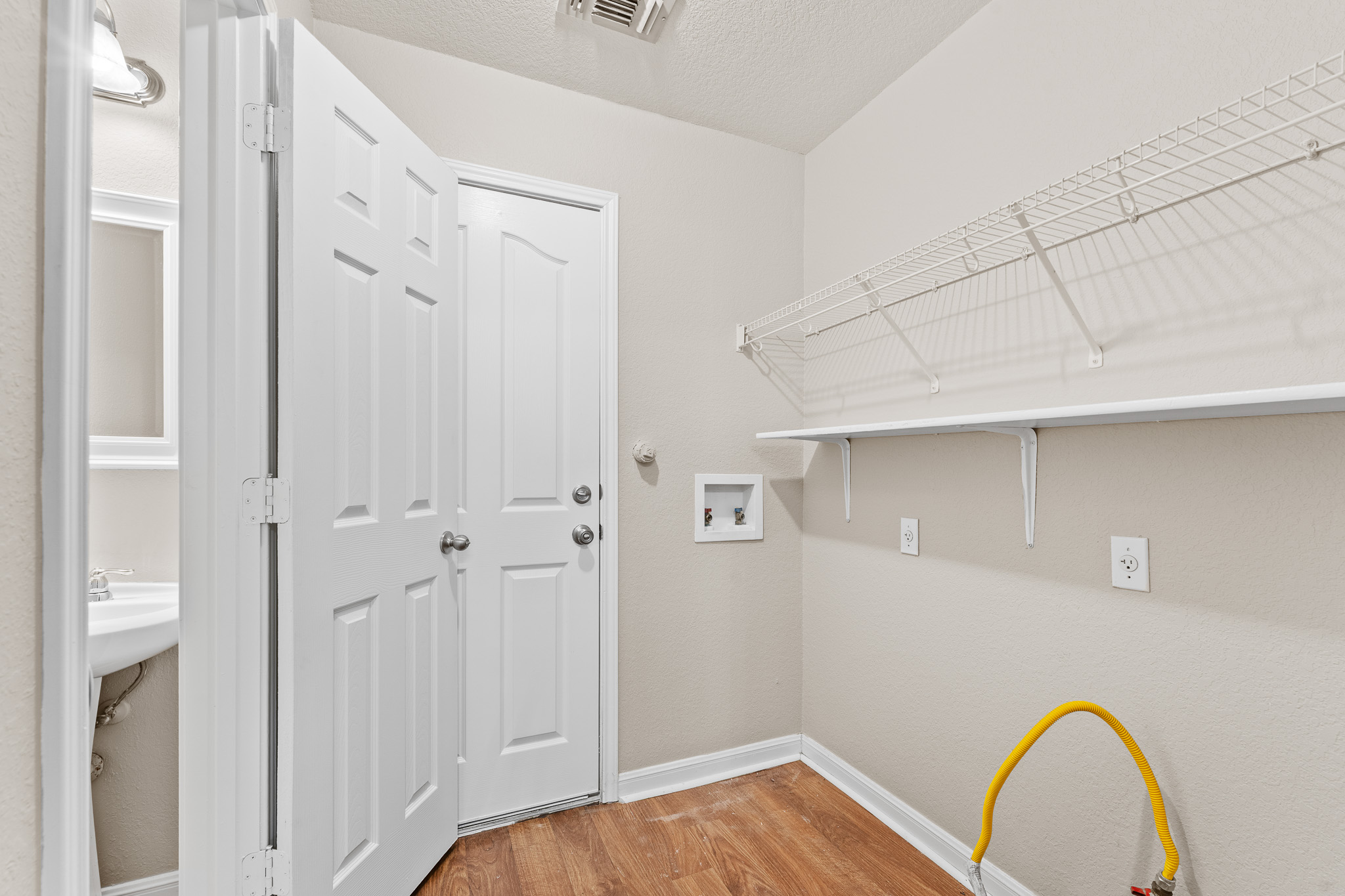 220 Trestle Tree San Marcos, TX 78666 - Photo 11 of 28 Washroom featuring light wood-style flooring, a textured ceiling, and hookup for a washing machine