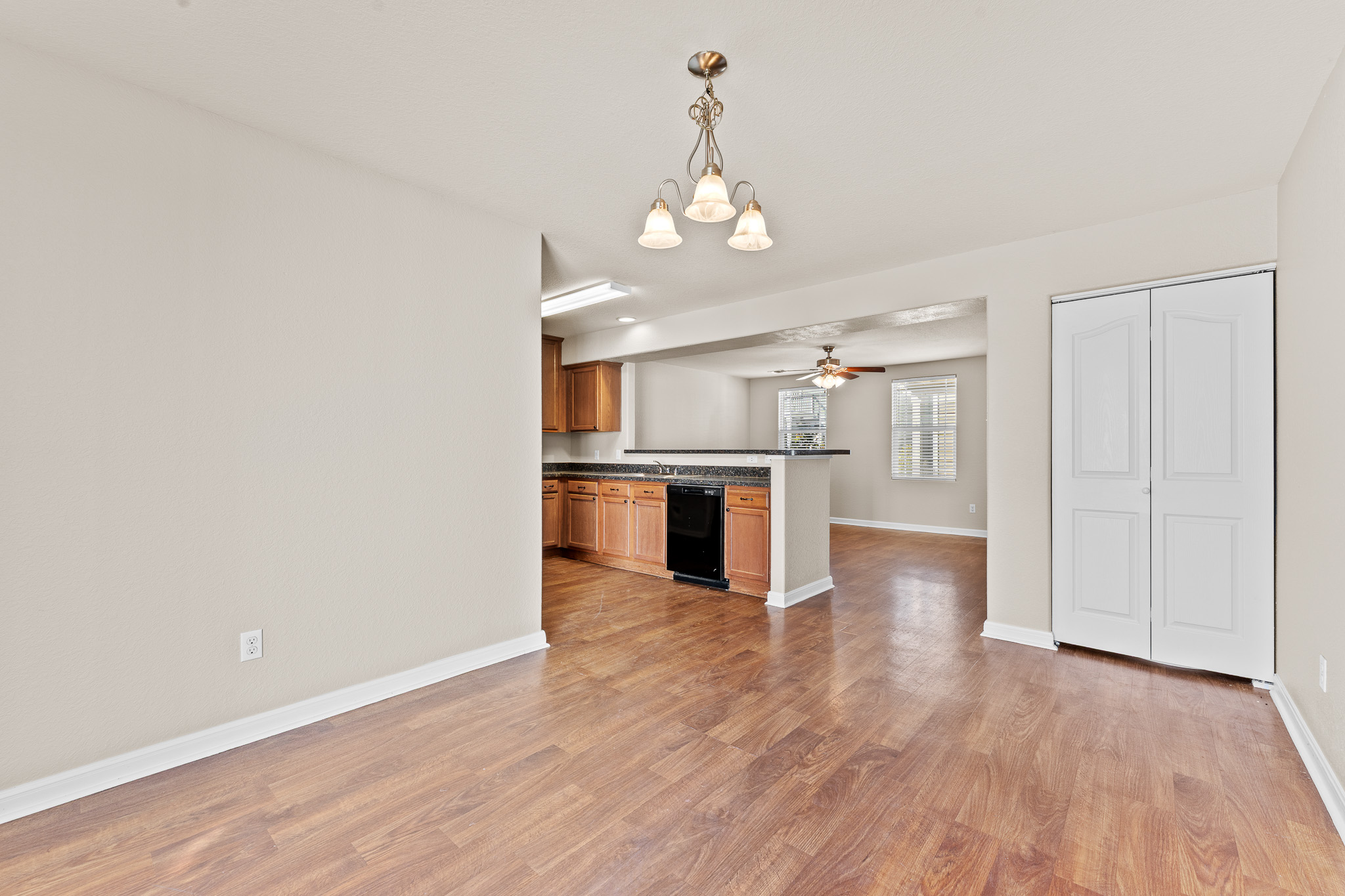220 Trestle Tree San Marcos, TX 78666 - Photo 25 of 28 Kitchen featuring decorative light fixtures, a chandelier, open floor plan, dishwasher, and light wood-style flooring