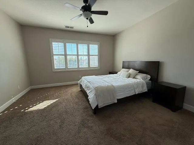 a bed sitting in a spacious bedroom next to a window
