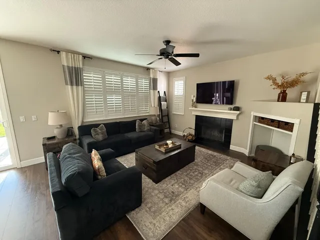 a living room with furniture a flat screen tv and a fireplace