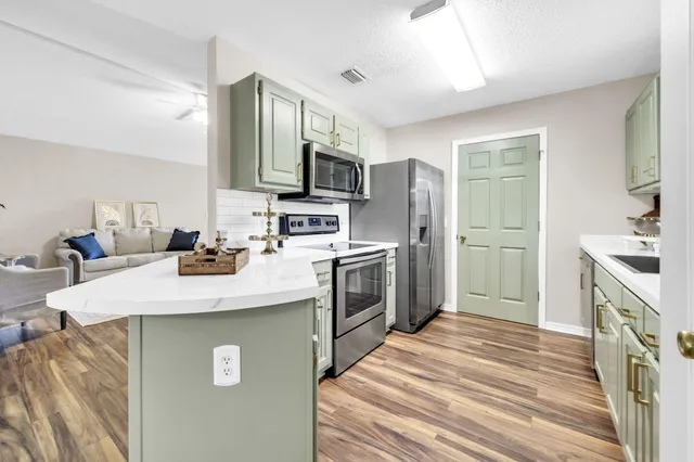 a kitchen with kitchen island a sink stainless steel appliances and cabinets
