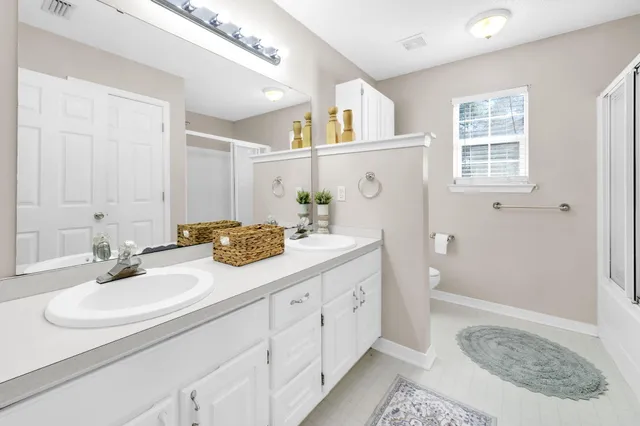 a bathroom with double sink and a mirror