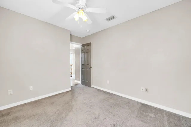 an empty room with a ceiling fan and a window