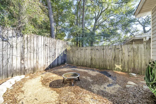 a backyard of a house with lawn chairs and wooden fence