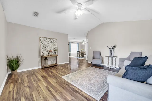 a living room with furniture and wooden floor