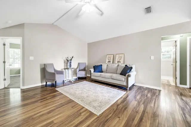a living room with furniture and a wooden floor