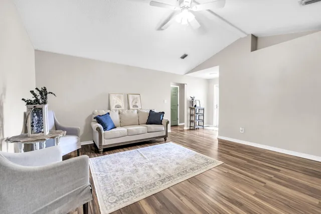 a living room with furniture and wooden floor