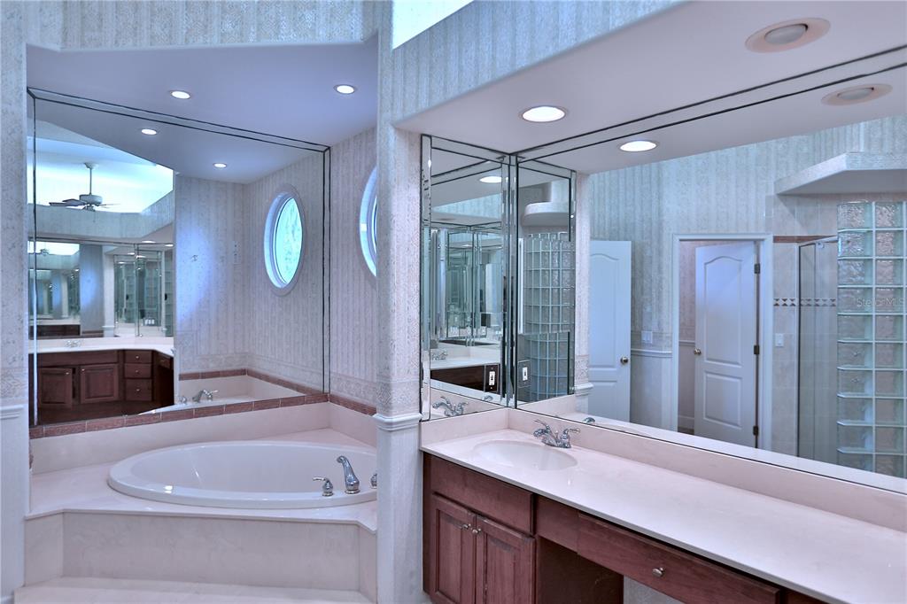 500 Southeast 69th Place Ocala, FL 34480 - Photo 34 of 46 a bathroom with a granite countertop sink a toilet a mirror and shower