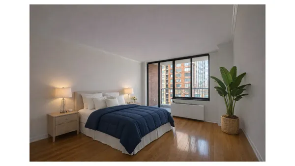 a bedroom with a large bed and a potted plant
