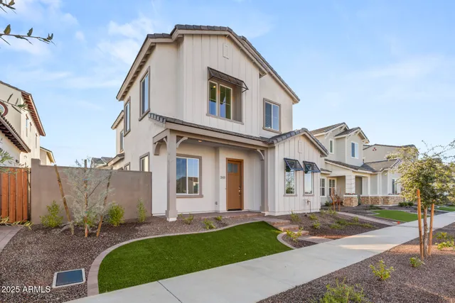 a view of a white house next to a yard