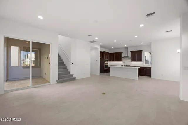 a large kitchen with stainless steel appliances a sink and a refrigerator