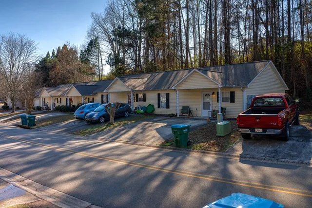 a front view of a house with cars parked