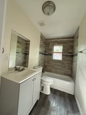 a bathroom with a sink a toilet and shower