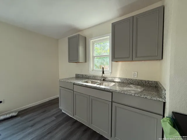 a kitchen with a sink cabinets and wooden floor