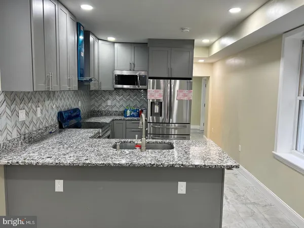 a kitchen with kitchen island granite countertop counter top space cabinets and stainless steel appliances