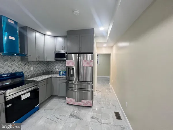 a kitchen with stainless steel appliances granite countertop a refrigerator and a sink