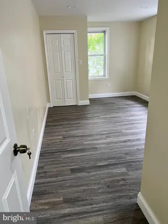 a view of a hallway with wooden floor and entryway
